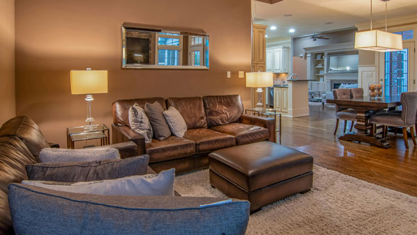 Cozy living room with leather sofa, armchair, and warm lighting, showcasing a clean and inviting home atmosphere.