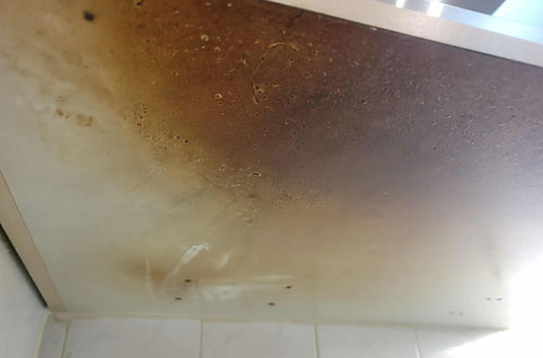 Dirty oven door glass with heavy grease and stains before professional deep cleaning service. Before and Afters